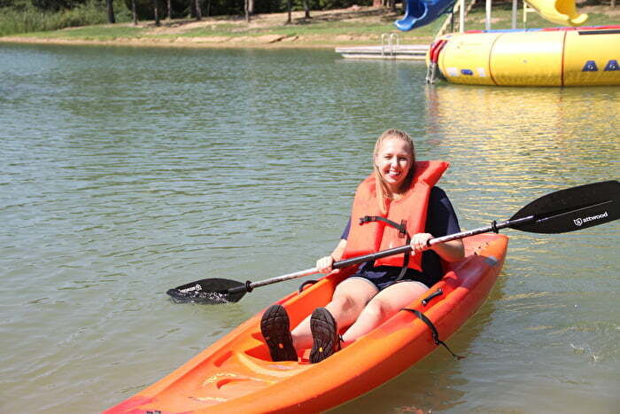 Girl in an orange kayak and life jacket on Lake Murray in Oklahoma