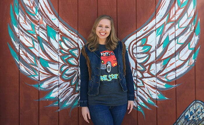 Girl in front of wing mural in Chickasaw Country