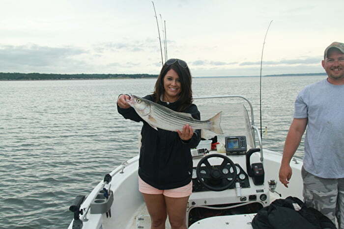 Woman holding fish on boat at Texoma Lake in Oklahoma